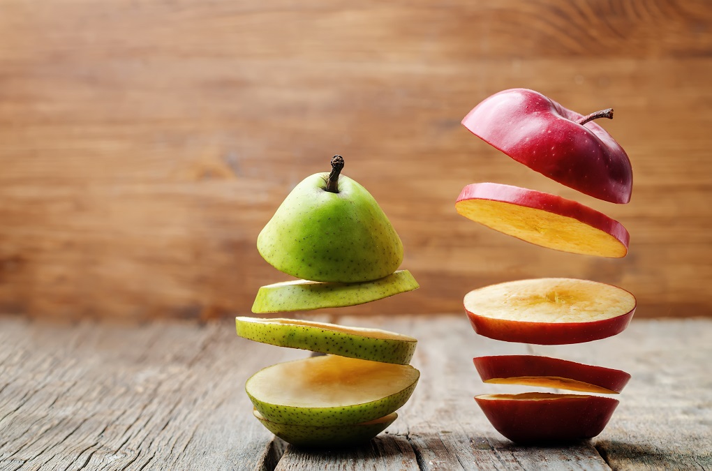 flying slices of fruit: apple, pear on a dark wood background. toning. selective Focus
